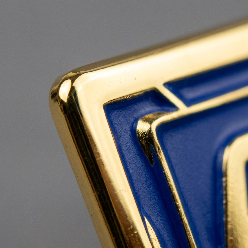 Detalle macro de esmalte suave: el color queda hundido bajo el borde metálico elevado